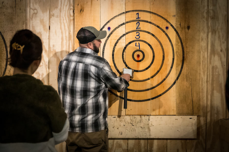 Grey Dog Axe Throwing in Marshfield, WI, removing axe from target.